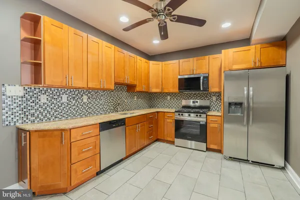 a kitchen with stainless steel appliances granite countertop a stove a sink and a refrigerator