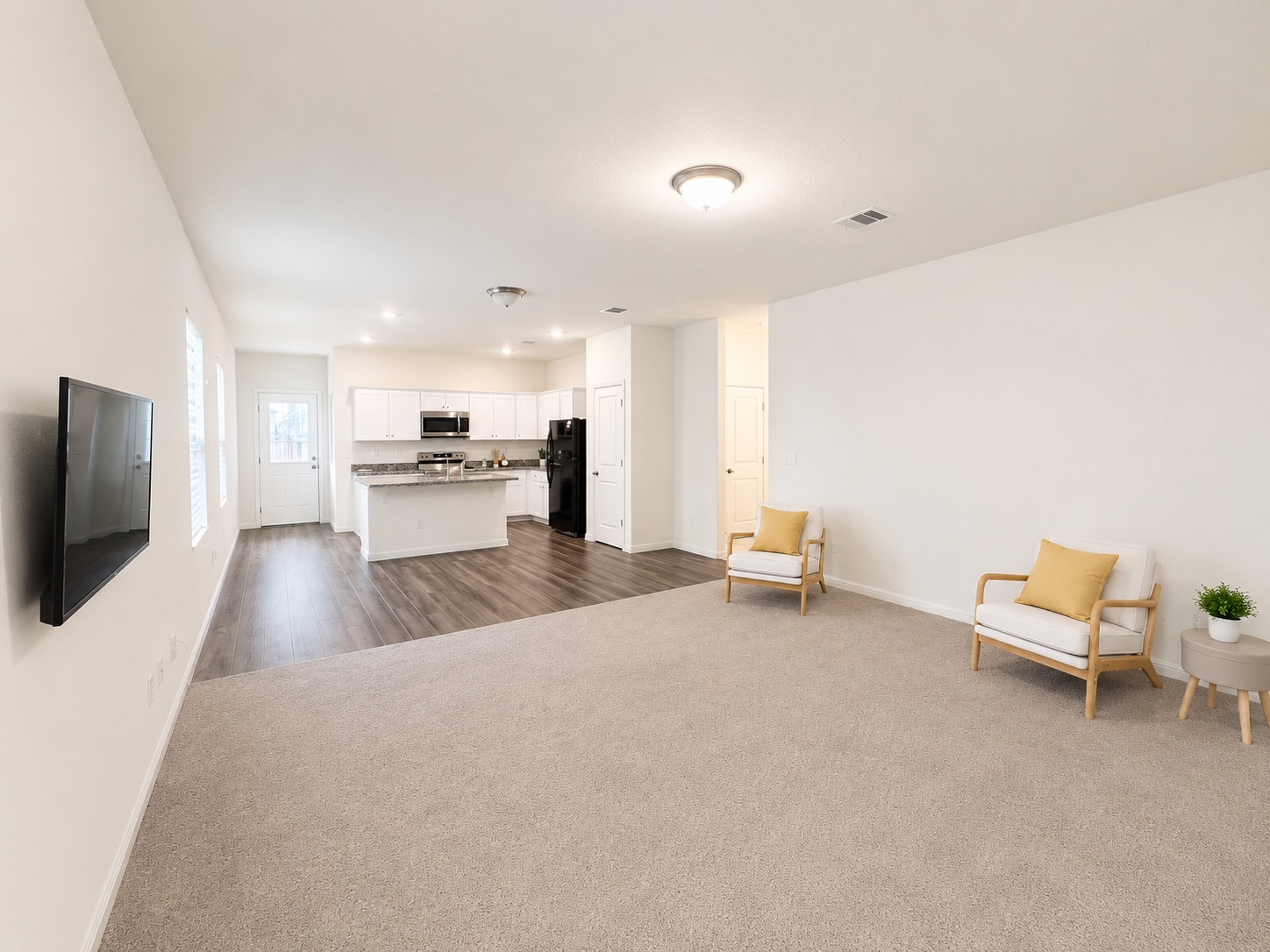 160 Light Timber Road Maxwell, TX 78656 - Photo 2 of 11 An open-concept living space with a contemporary kitchen and inviting carpeted lounge area.
