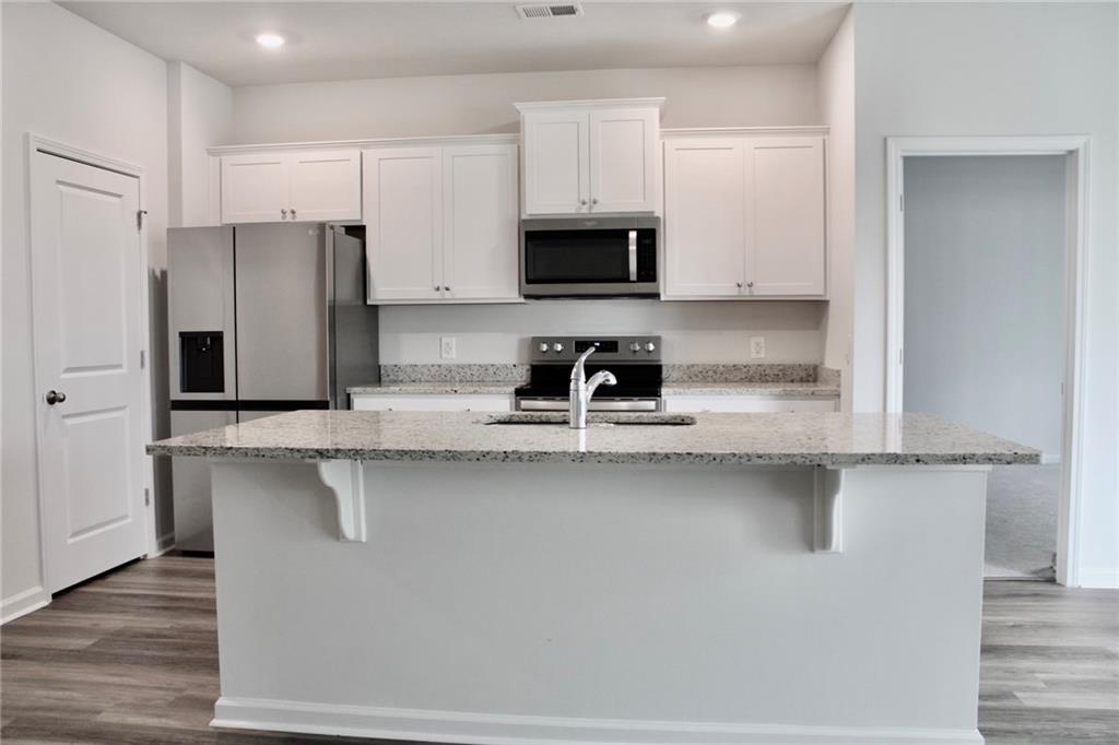 102 Fremont Lane Pooler, GA 31322 - Photo 4 of 10 a kitchen with stainless steel appliances a sink a stove a refrigerator and cabinets