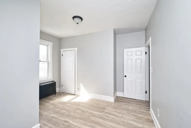 an empty room with wooden floor and closet