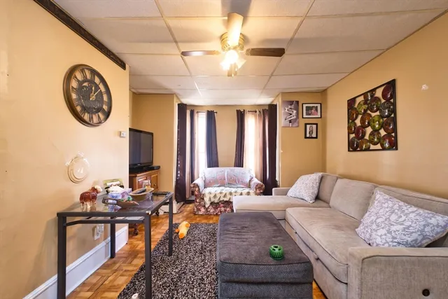 a living room with furniture and wall paintings