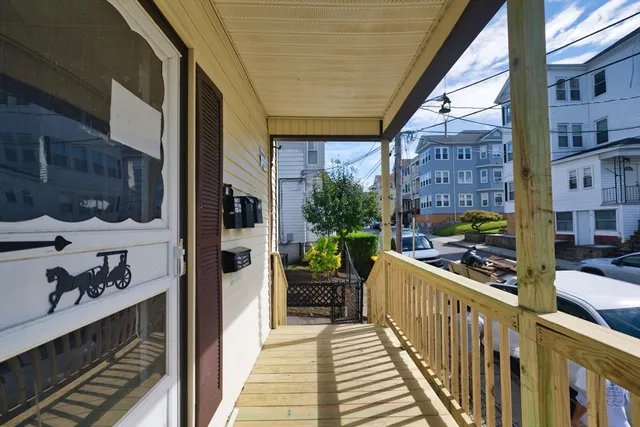 a view of a balcony with chairs and a stove