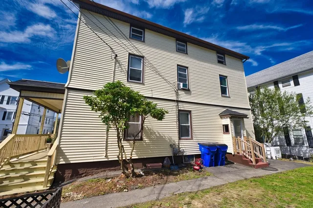 a small white building with a white roof and table and chairs next to window
