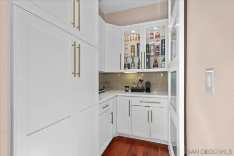 a kitchen with white cabinets and window