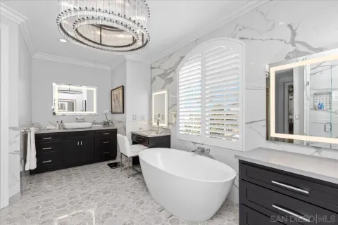 a spacious bathroom with a double vanity sink a two mirror and a tub