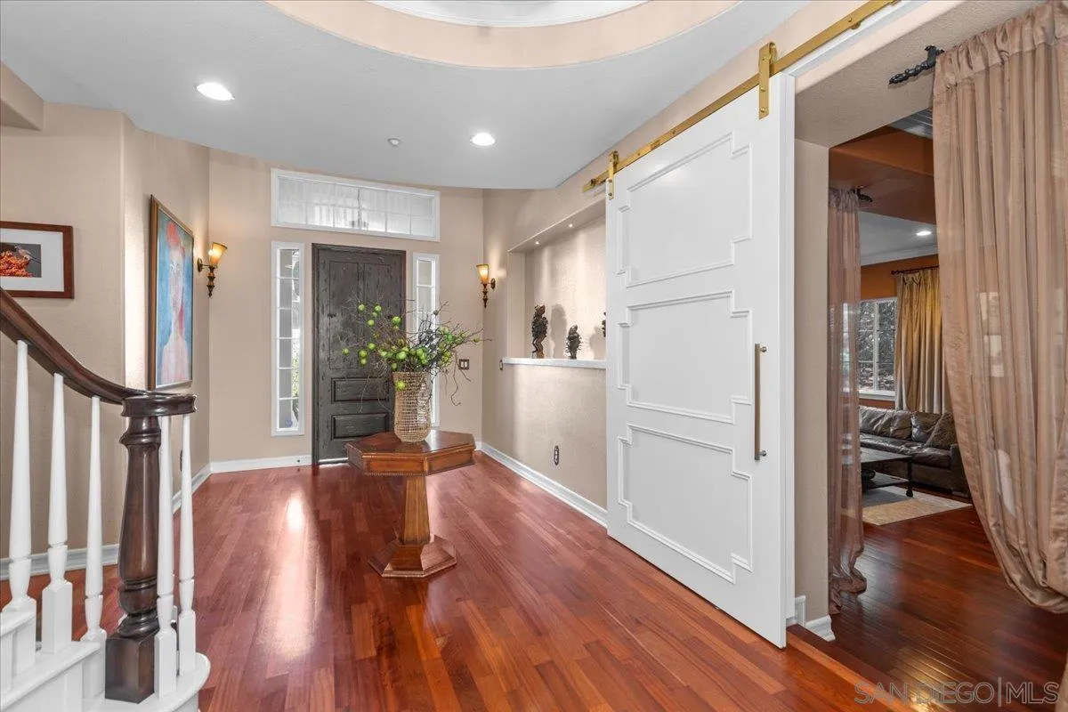 515 Verbena Court Encinitas, CA 92024 - Photo 7 of 42 a view of a hallway with wooden floor and a living room