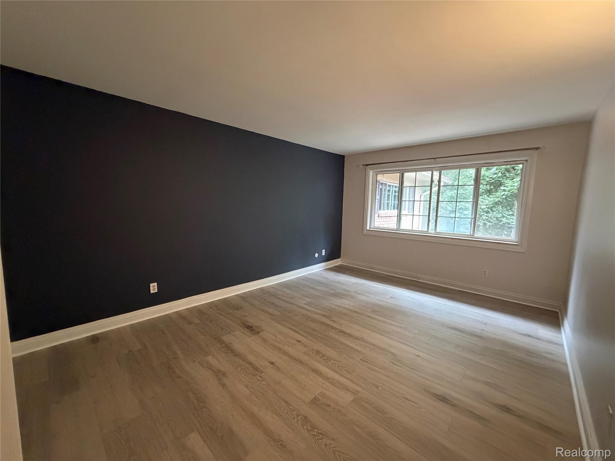2245 Walton Blvd., Unit 56 Rochester, MI 48309 - Photo 9 of 15 Wood-finish flooring with a contrasting accent wall