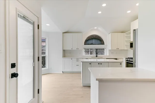 a bedroom with a bed a mirror on the wall and a window