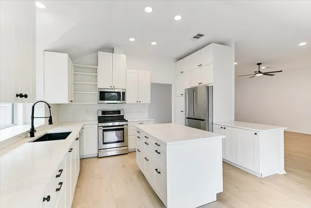 a kitchen with stainless steel appliances granite countertop a stove and a sink