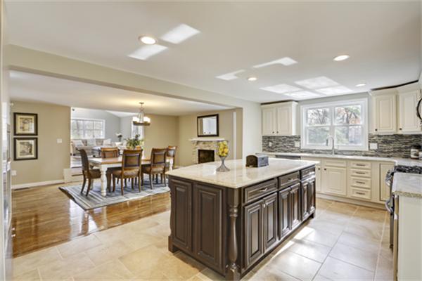 a large kitchen with kitchen island a sink counter and chairs