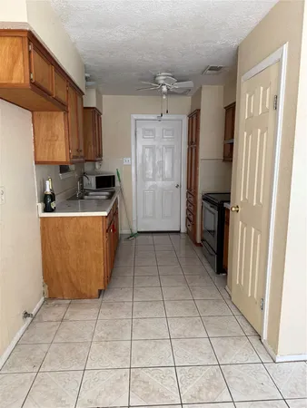 a view of a kitchen with kitchen island granite countertop a refrigerator and a sink
