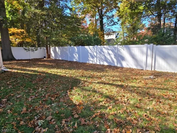 a view of a yard with wooden fence