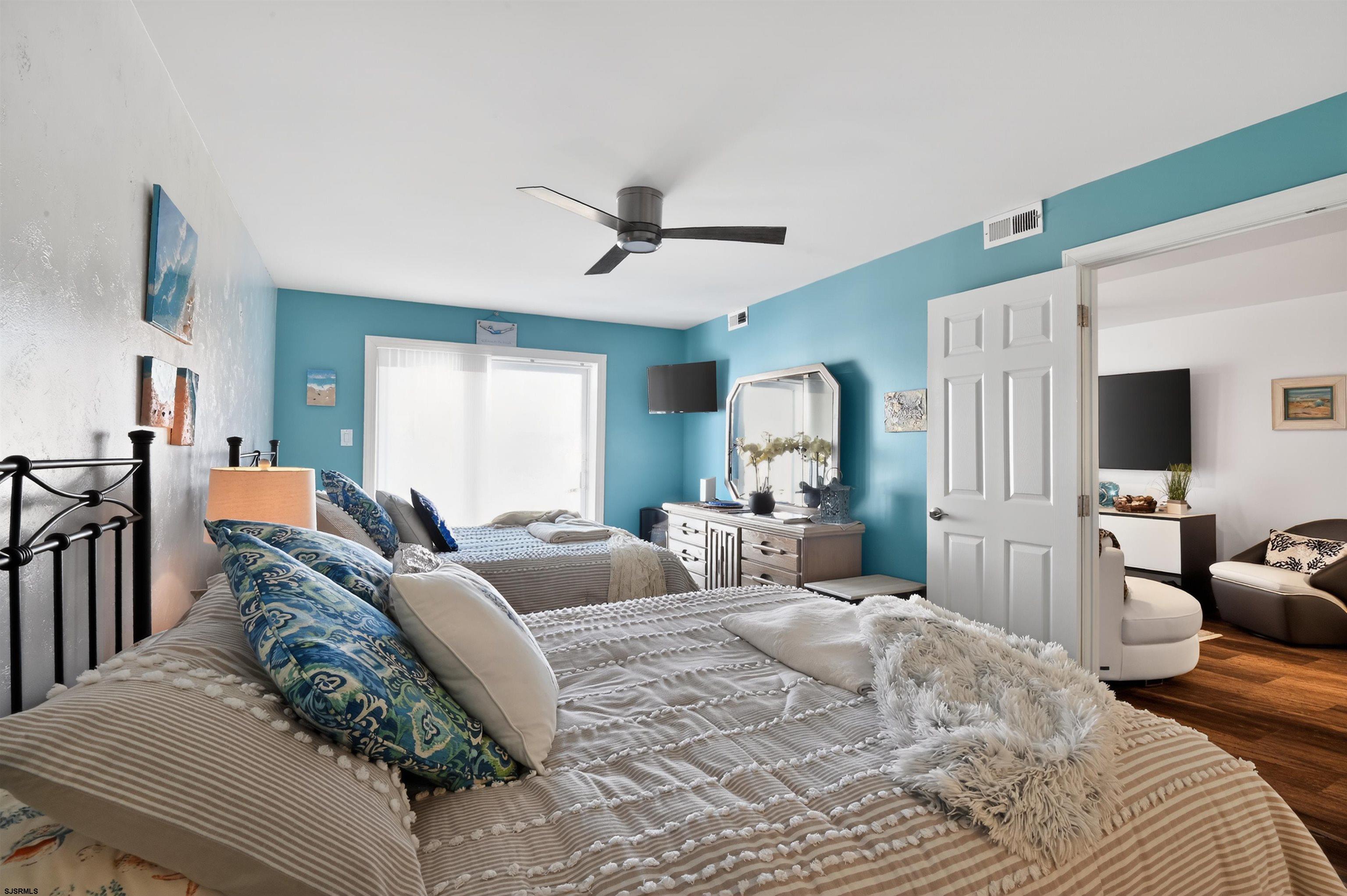 3901 Ocean Avenue, Unit 6 Brigantine, NJ 08203 - Photo 11 of 24 a bedroom with a large bed a flat screen tv and a couch