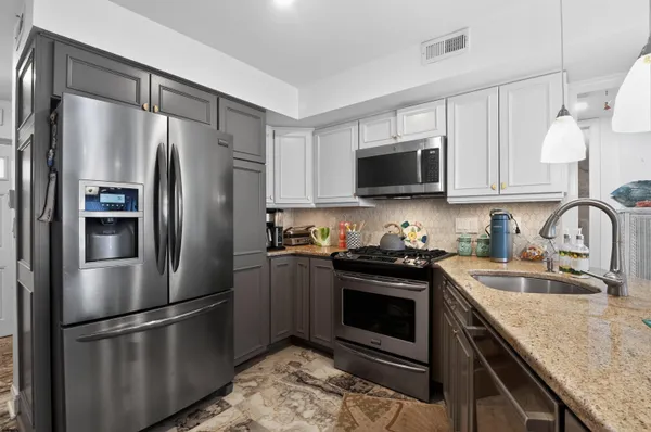 a kitchen with stainless steel appliances granite countertop a stove a refrigerator and a sink