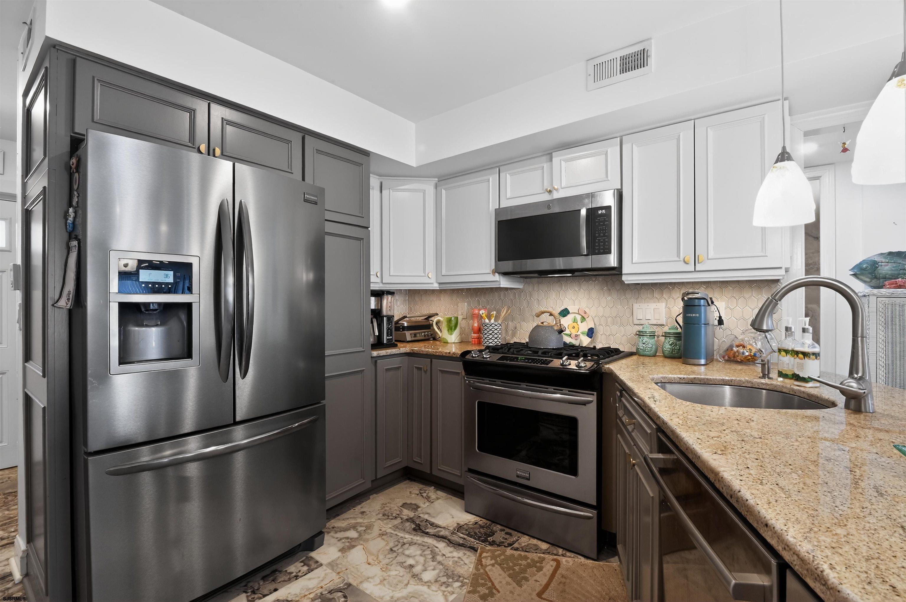 3901 Ocean Avenue, Unit 6 Brigantine, NJ 08203 - Photo 2 of 24 a kitchen with stainless steel appliances granite countertop a stove a refrigerator and a sink