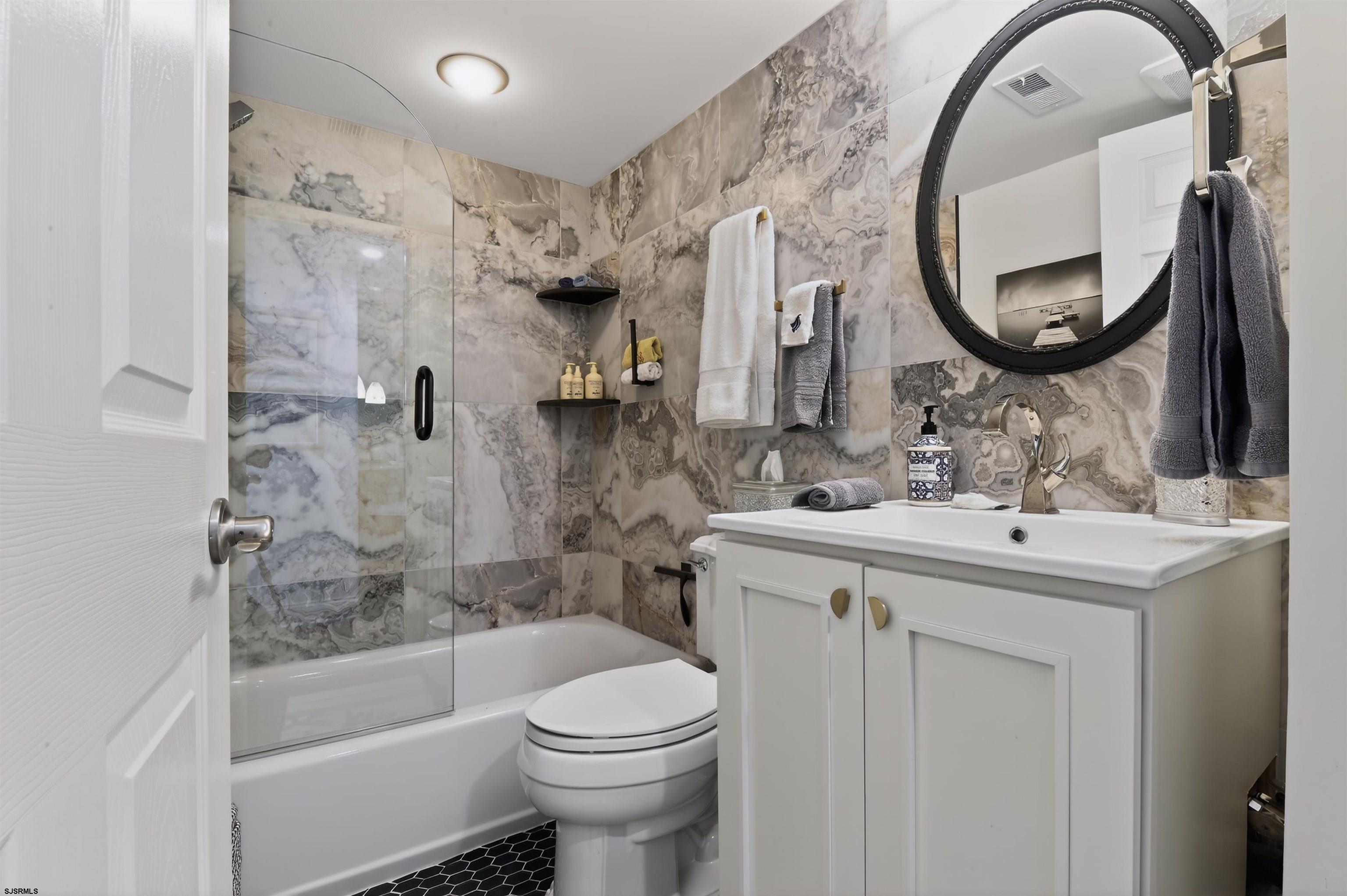 3901 Ocean Avenue, Unit 6 Brigantine, NJ 08203 - Photo 10 of 24 a bathroom with a sink a toilet and a mirror