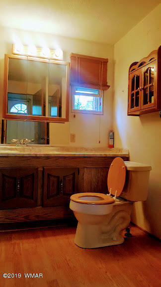 4381 East Blue Ridge Loop, Unit 3 Pinetop, AZ 85935 - Photo 12 of 16 a bathroom with a toilet sink and mirror