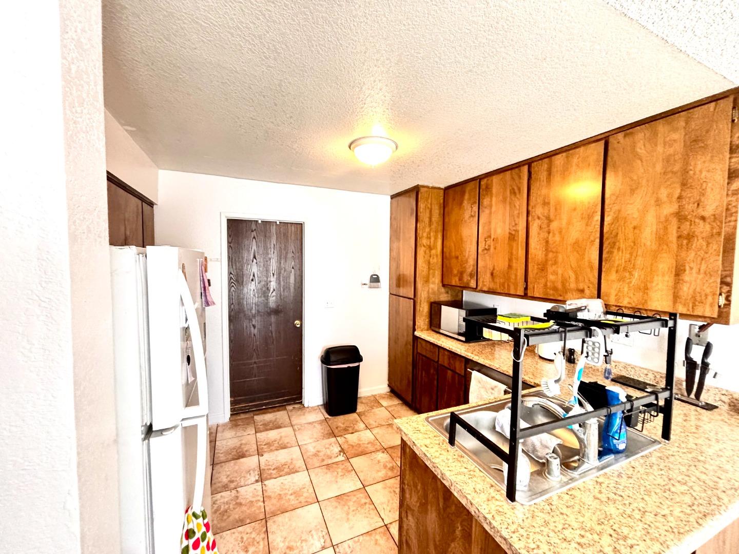 1752 Duffy Way San Jose, CA 95116 - Photo 8 of 14 a kitchen with stainless steel appliances kitchen island granite countertop a refrigerator and a stove top oven
