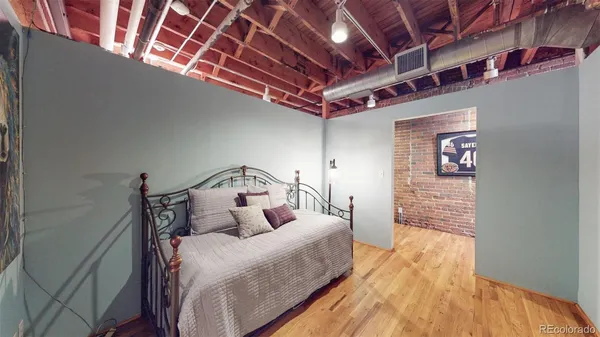 a bed room with a bed and a wooden floor