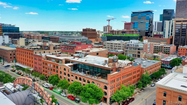 a building view with tall trees and outdoor seating space