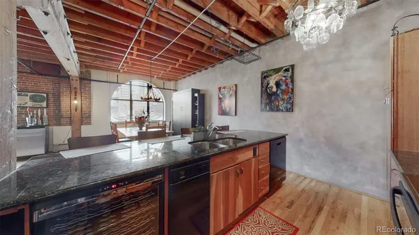a kitchen with stainless steel appliances granite countertop a sink a stove and a wooden floors