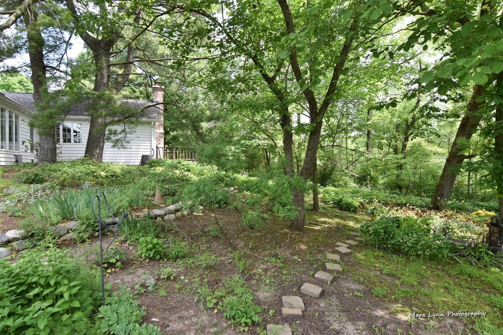 33W981 Army Trail Road Wayne, IL 60184 - Photo 54 of 71 a backyard of a house with lots of plants and large trees