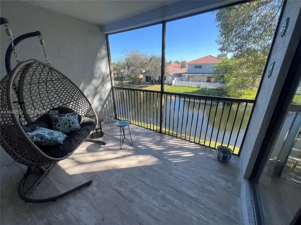 a view of a balcony with chair and wooden floor