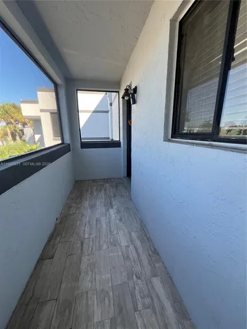 a view of hallway with wooden floor and door
