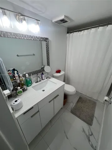 a bathroom with a sink and mirror with toilet