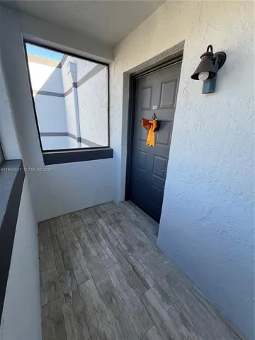 a view of a hallway view with wooden floor and cabinet