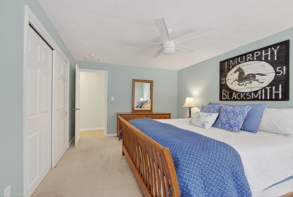 11 Smoke Rise Drive Chelmsford, MA 01824 - Photo 19 of 28 a bedroom with a bed and a chandelier