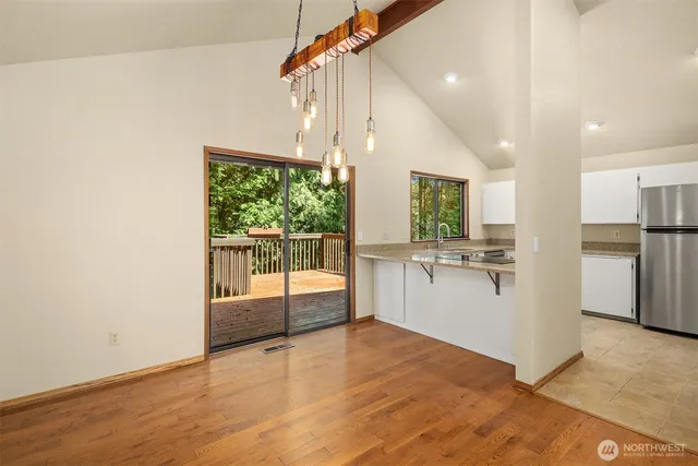 a view of a kitchen with kitchen island a counter top space wooden floor and appliances