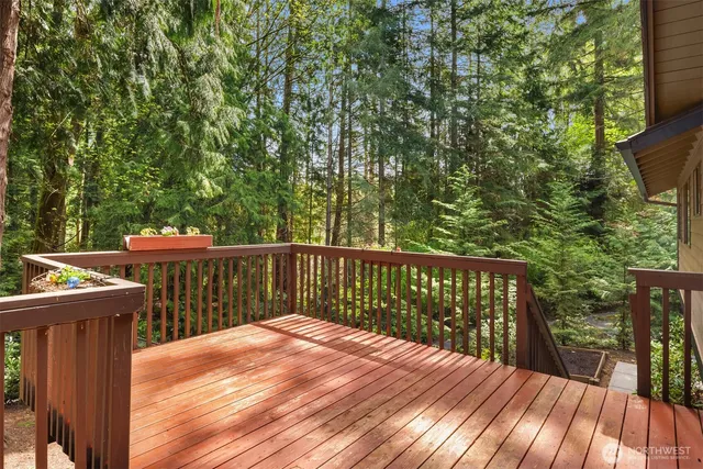 a balcony with wooden floor and yard in the back