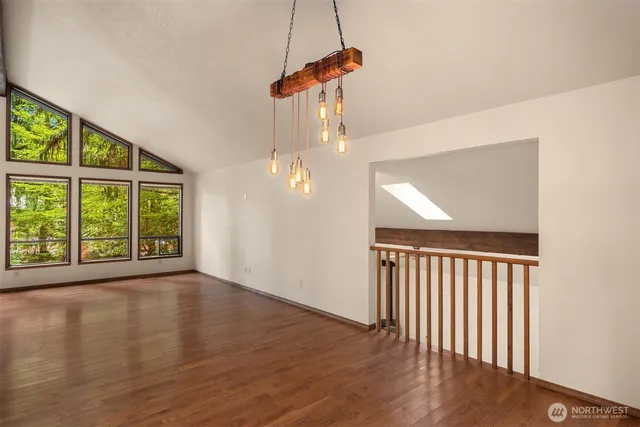 a view of a room with wooden floor fan and windows