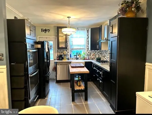 a kitchen with stainless steel appliances kitchen island granite countertop furniture a refrigerator and a dining table