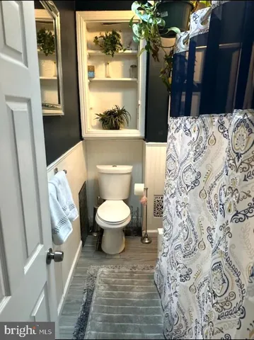 a bathroom with a toilet and a shower curtain