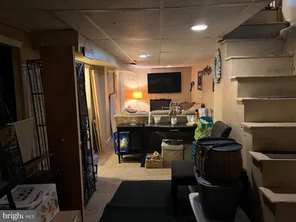 a room with furniture a flat screen tv and a view of kitchen