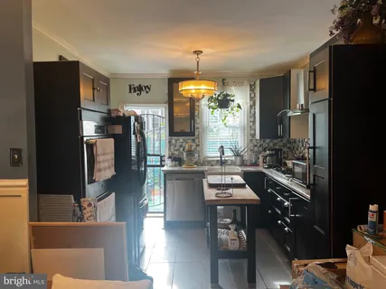 a kitchen with stainless steel appliances kitchen island granite countertop a refrigerator and a stove