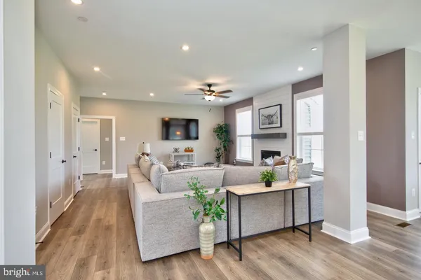 a living room with furniture wooden floor and a kitchen view