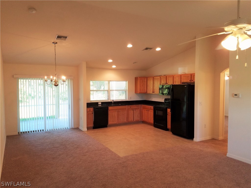2910 25th Street West Lehigh Acres, FL 33971 - Photo 2 of 15 a kitchen with stainless steel appliances kitchen island granite countertop a refrigerator and a sink