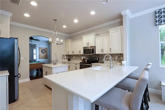 a kitchen with a dining table chairs refrigerator and cabinets
