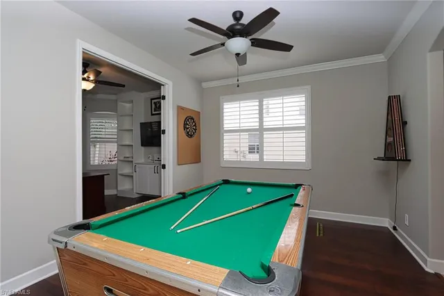 a room with pool table and windows
