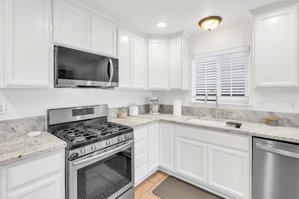 915 Rancho Roble Way Sacramento, CA 95834 - Photo 1 of 1 a kitchen with granite countertop a sink stove and microwave