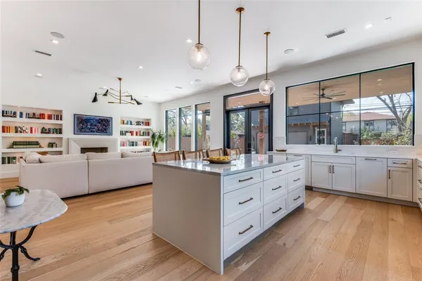 a kitchen with stainless steel appliances kitchen island wooden floors and white cabinets