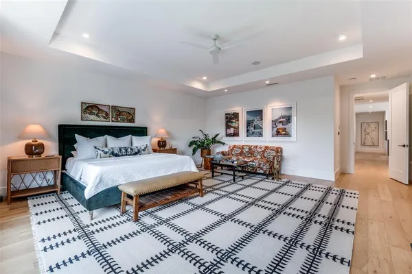 a spacious bedroom with a bed a mirror and lamp