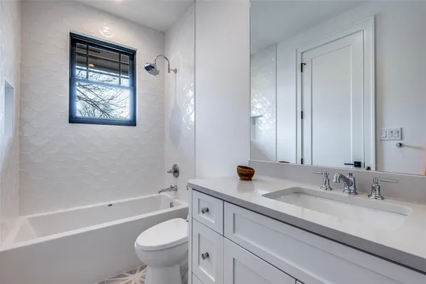 a bathroom with a granite countertop sink a toilet and a bathtub