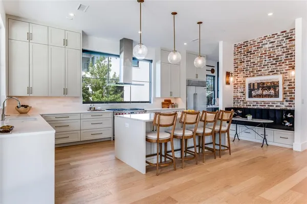 a kitchen with stainless steel appliances kitchen island granite countertop a stove a sink a dining table and chairs