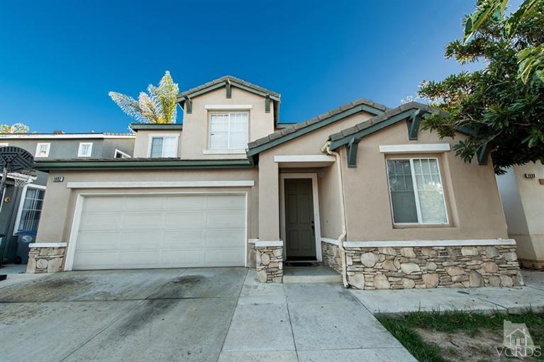 1892 Ribera Drive Oxnard, CA 93030 - Photo 2 of 34 a front view of a house with a yard and garage