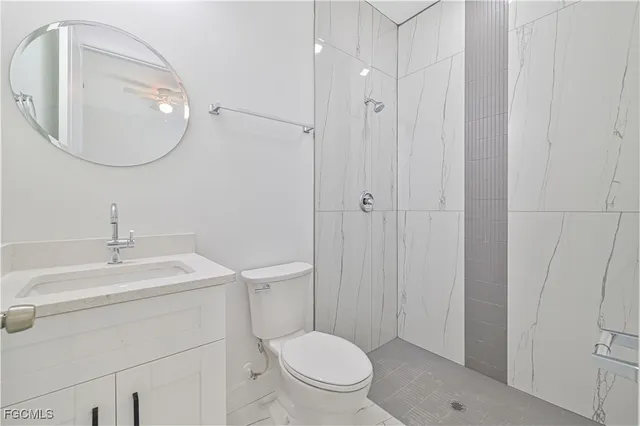 a bathroom with a toilet a sink a mirror and vanity