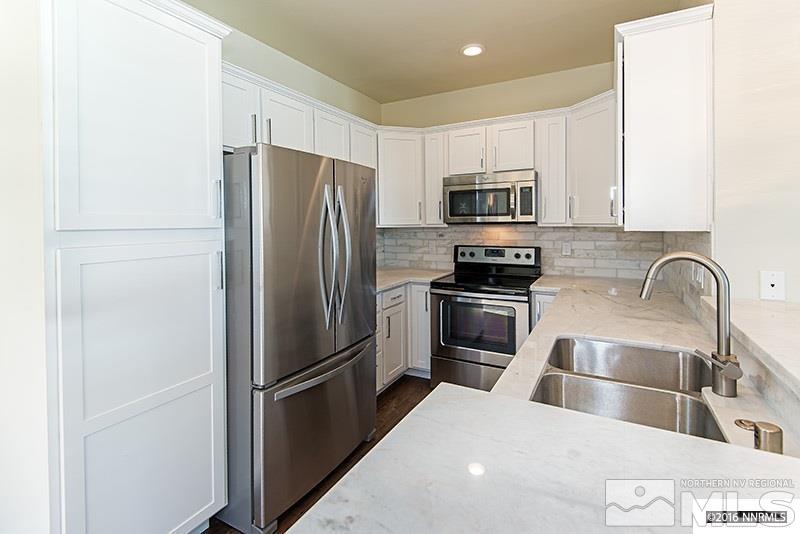 711 Roberts Street Reno, NV 89502 - Photo 2 of 13 a kitchen with a refrigerator sink and stainless steel appliances
